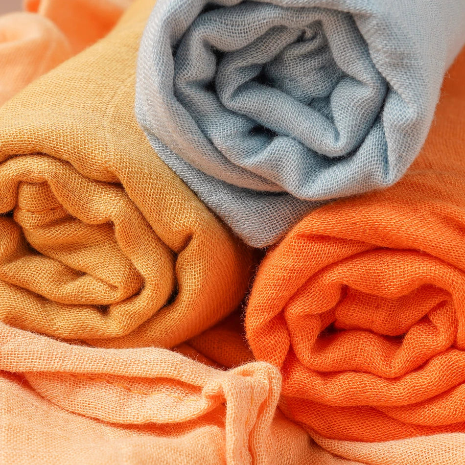 Stack of folded orange, yellow, and blue fabrics