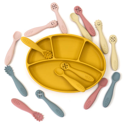 Yellow silicone plate with multiple utensils on a white background