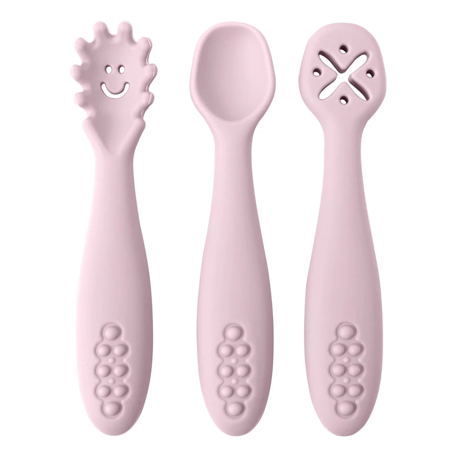 Set of three pink baby utensils with different designs on a white background