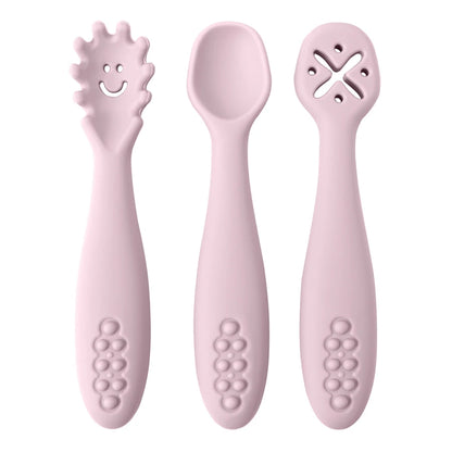 Set of three pink baby utensils with different designs on a white background