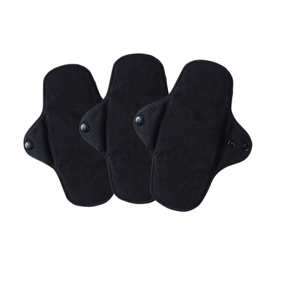 Three black cloth pads with adhesive patches on a white background