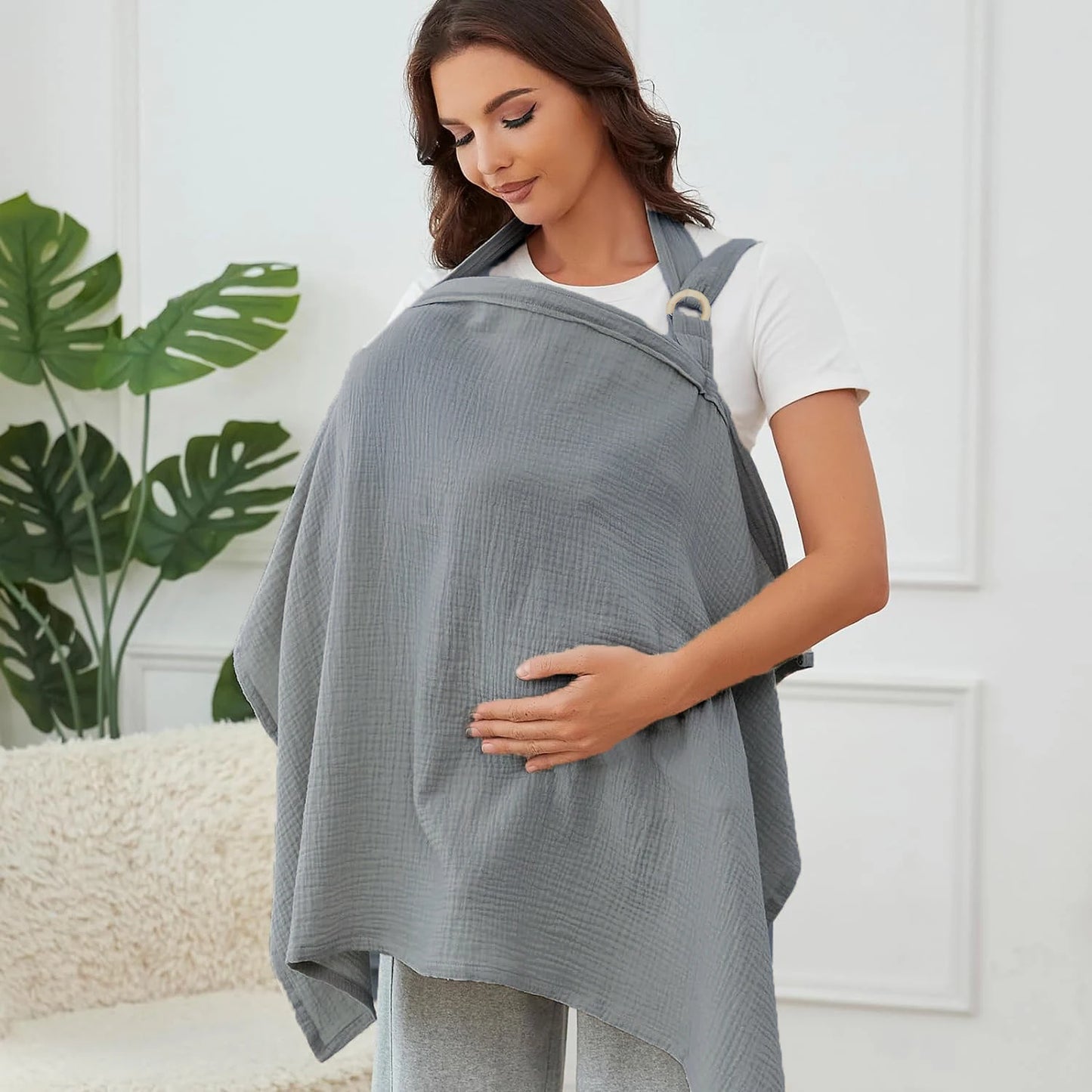 Woman wearing a gray baby carrier with a white background