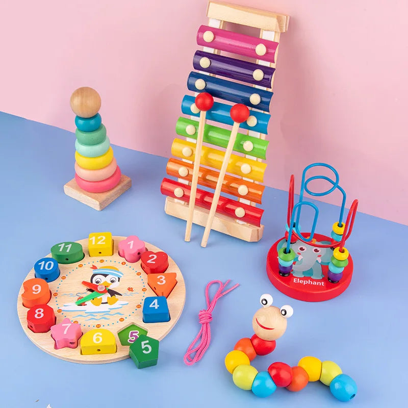 Collection of colorful wooden toys on a blue surface with a pink background