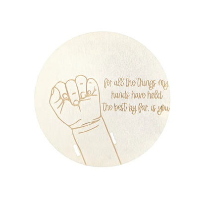 Round beige coaster with gold hand illustration and text on a white background
