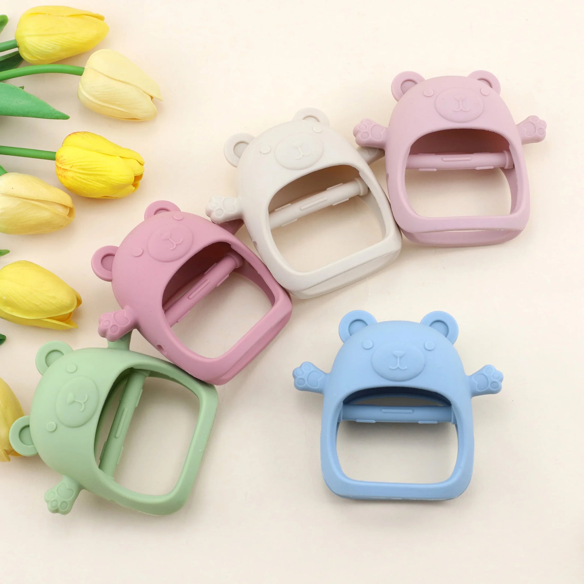 Colorful bear-shaped plastic buckles on a light background with yellow tulips.