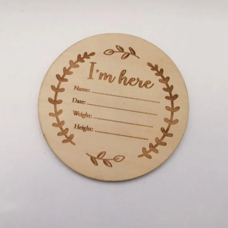 Round wooden card with engraved text and leaf design on a white background
