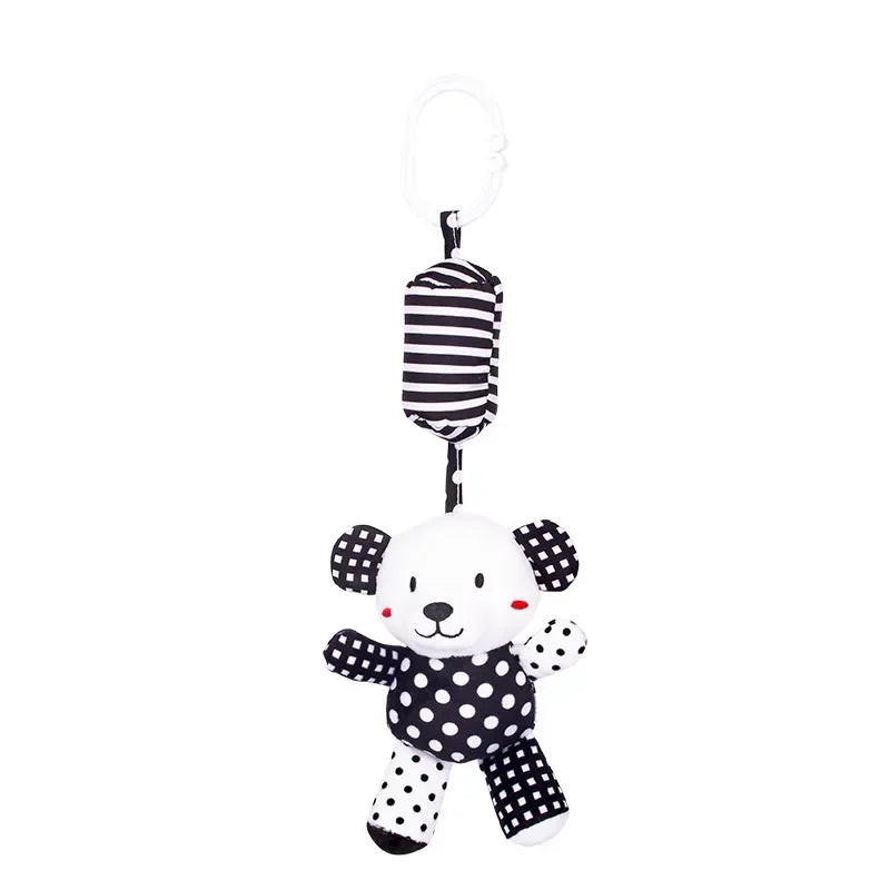 Black and white polka dot toy with striped hanging part on a white background
