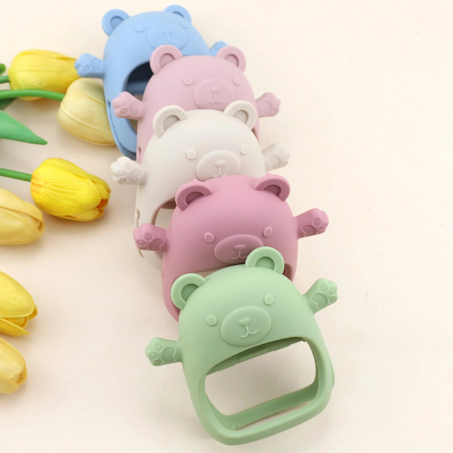 Set of colorful bear-shaped bottle caps with tulips on a light background