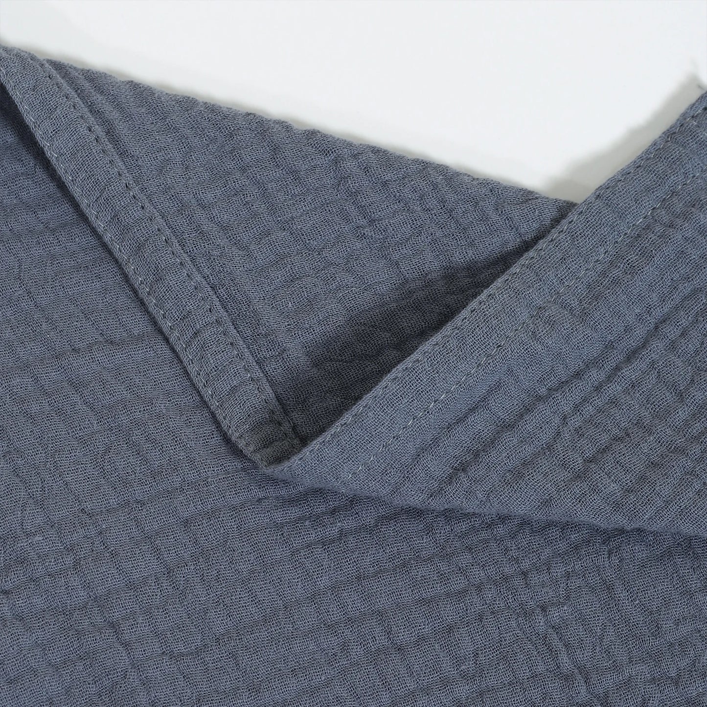 Close-up of textured blue fabric with a white background