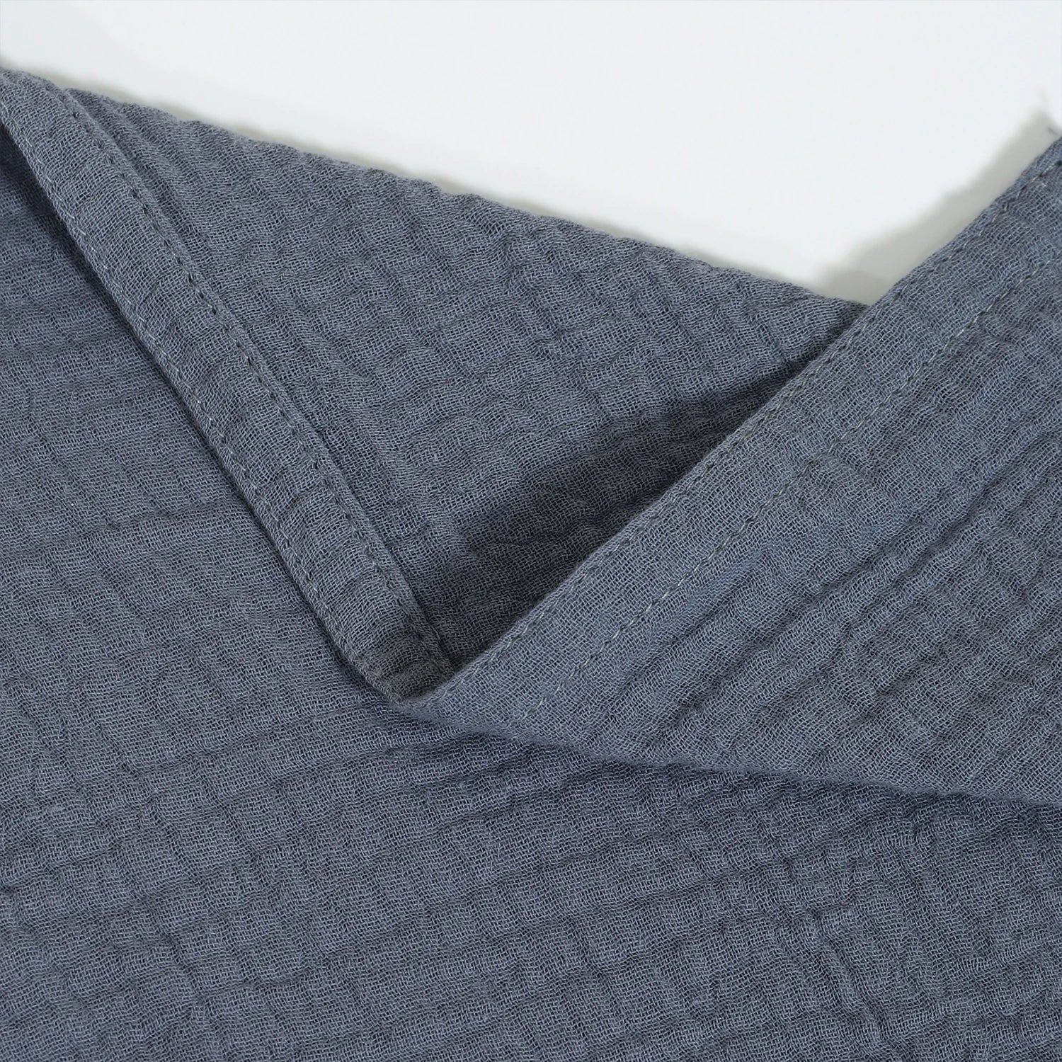 Close-up of textured blue fabric with a white background