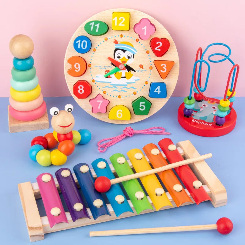 Assorted children's toys including a xylophone, clock, and stacking rings on a pink background
