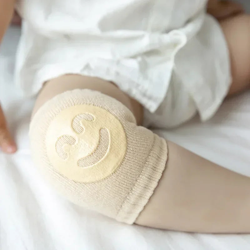 Beige elbow pad on a child's arm with a white background