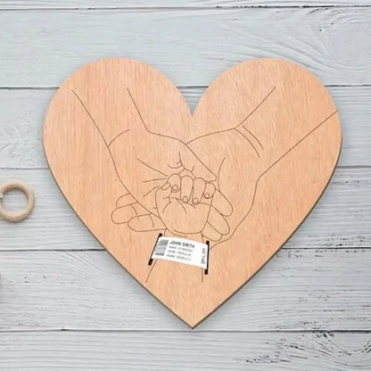 Wooden heart-shaped plaque with engraved hands holding a ring on a light wooden background