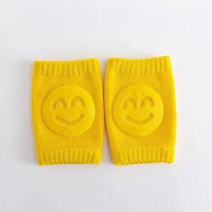 Pair of yellow knee pads with smiley face designs on a white background