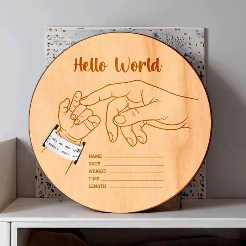 Wooden plaque with engraved baby milestone design on a shelf.