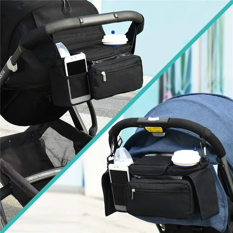 Black stroller organizer with phone holder and diaper bag attached to a stroller.