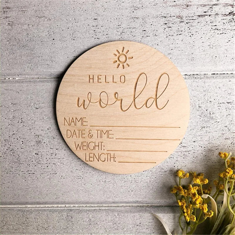 Round wooden board with 'Hello World' engraving on a textured surface with flowers.