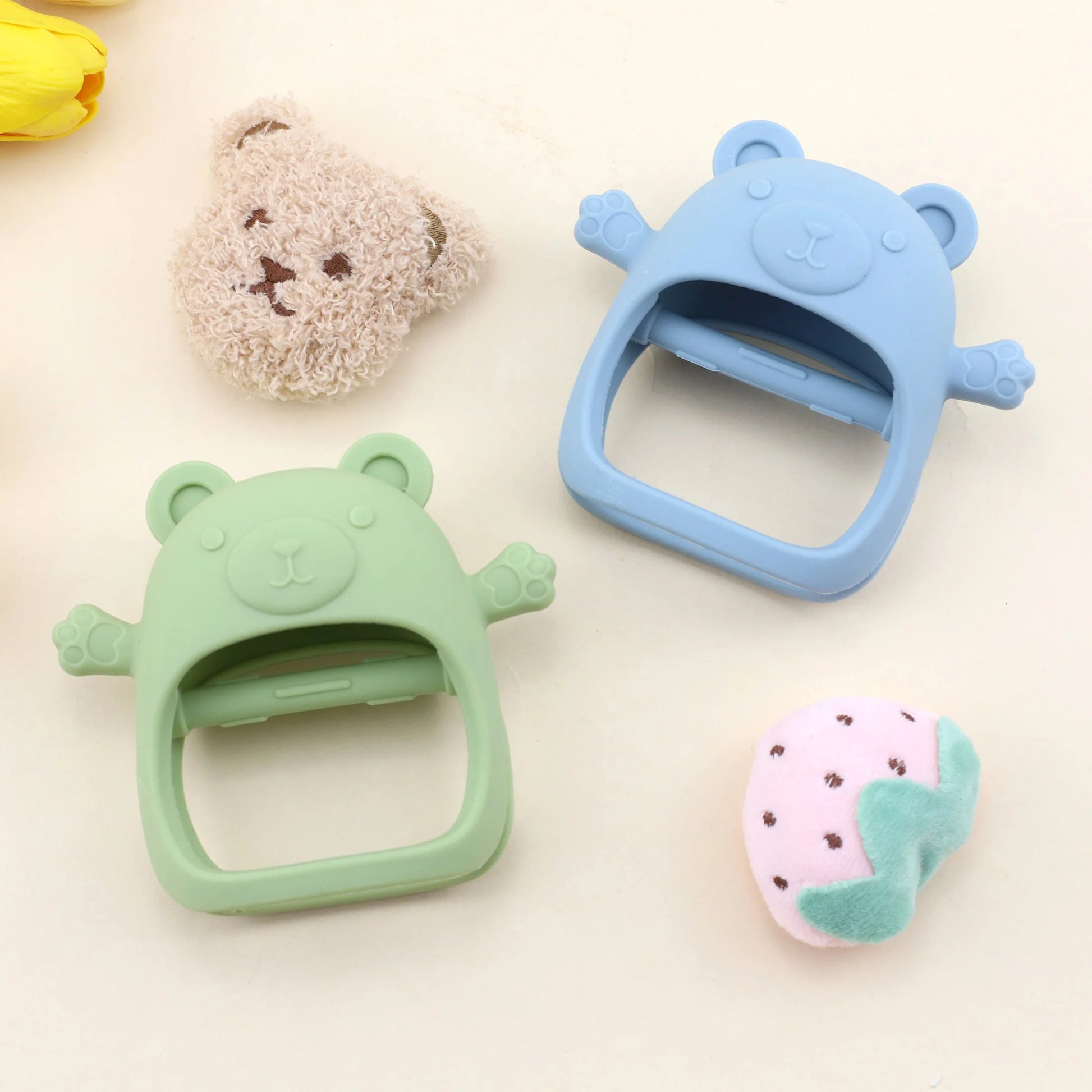 Two bear-shaped clips, one green and one blue, on a light background with small toys.