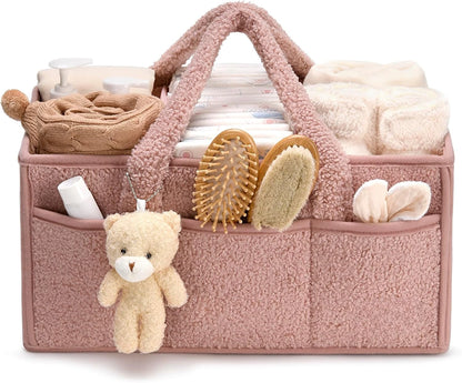 Pink baby organizer with teddy bear, diapers, and other items on a white background
