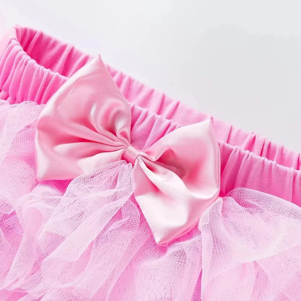 Close-up of a pink tutu with a large bow on a white background