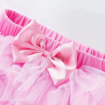Close-up of a pink tutu with a large bow on a white background